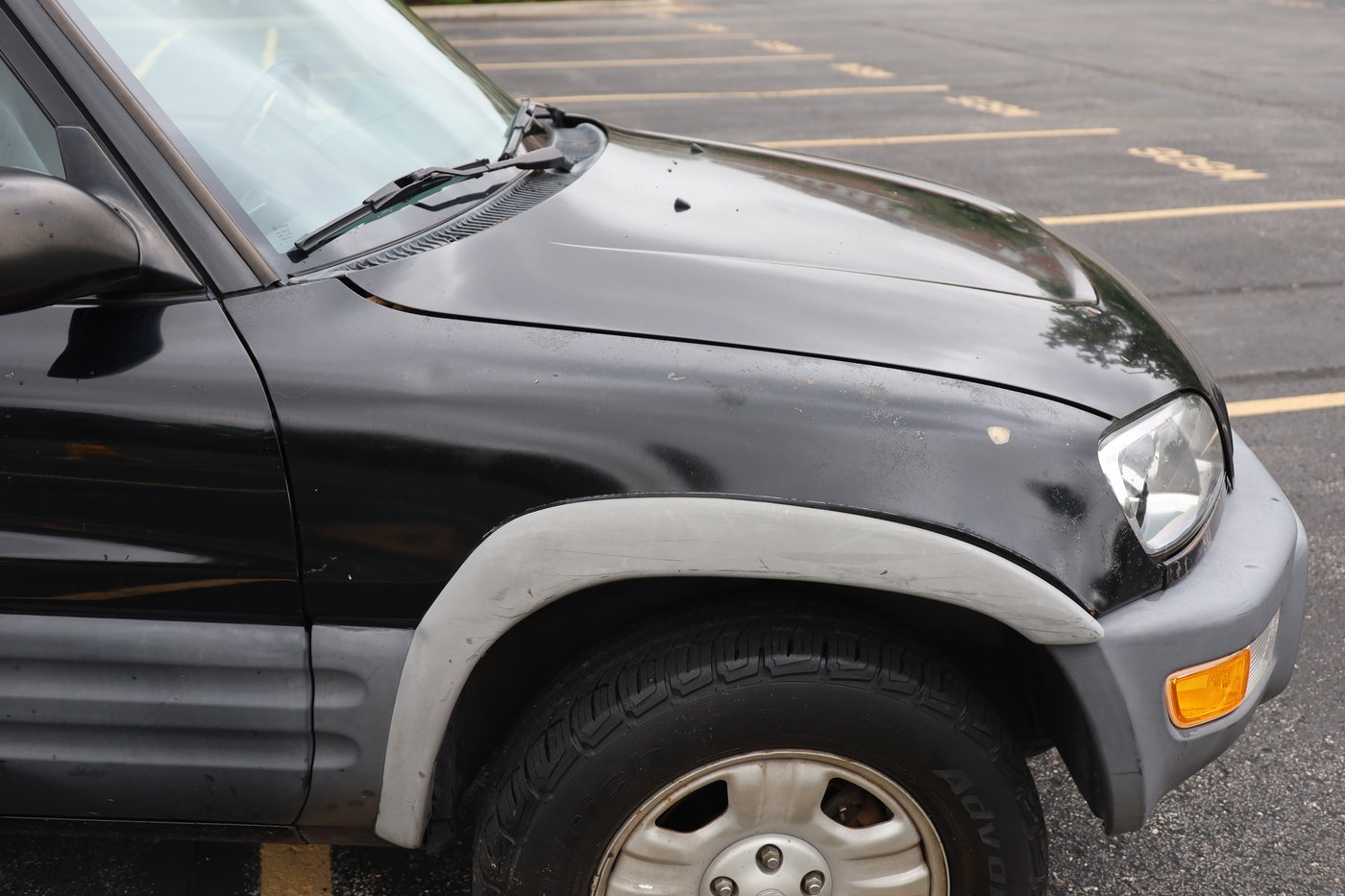 Close-up of poorly repainted side panel with chipping paint