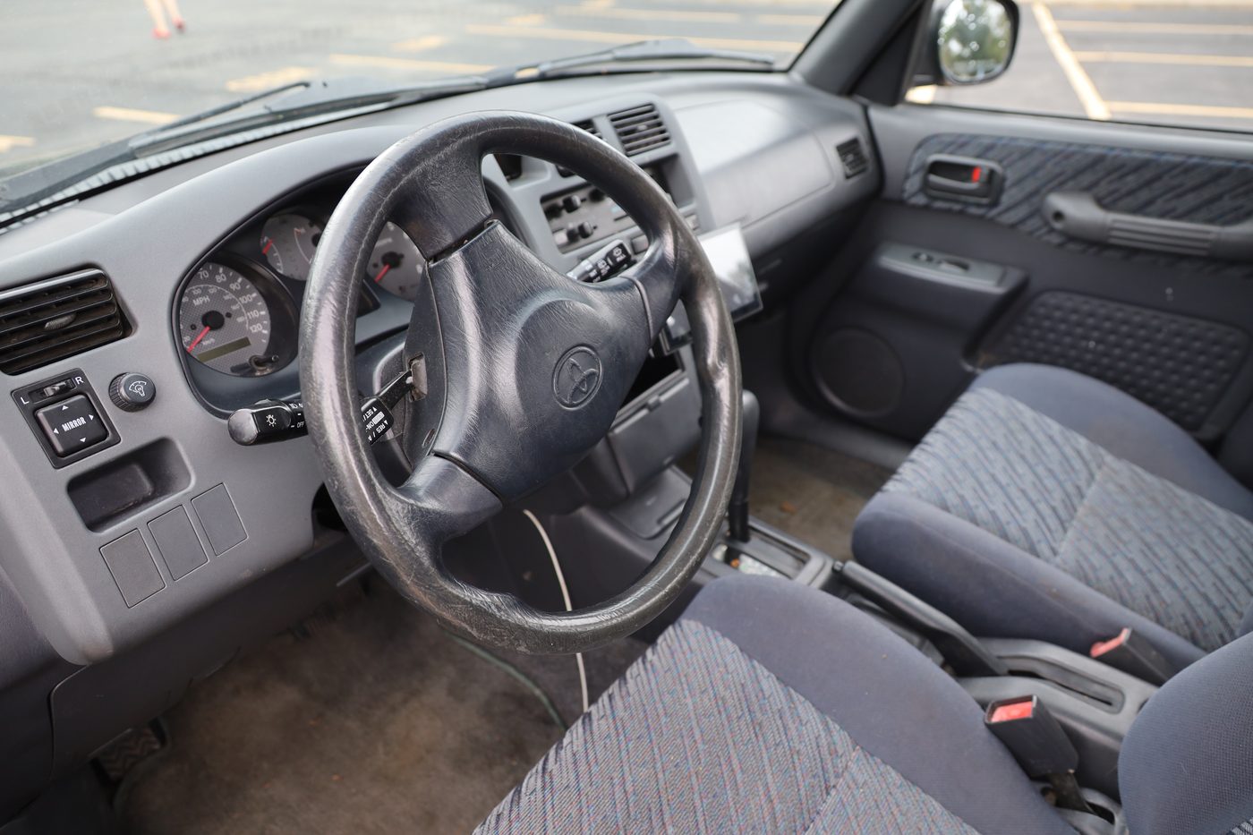 Driver cockpit with steering wheel, dashboard, and front seats